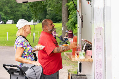 A couple getting iced teas from a foo truck