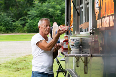 a man receiving a tray of food from a food truck