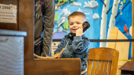 A young boy pretends to talk on a telephone at the Bloomsburg Children's Museum in Bloomsburg, PA.