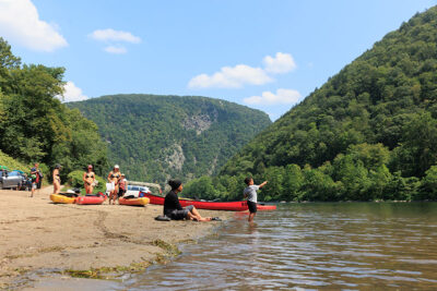 A group of paddlers take a rest on the shoreline of the Delaware River in Delaware Water Gap, PA.