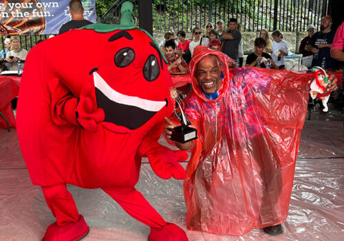 The spaghetti contest winner poses with the Tomato Festival mascot at the Pittston Tomato Festival in Pittston, PA.