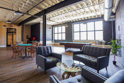 A view into the community room with seating areas, a pool table and a poker table at the Waterfront Warehouse in Pittston, PA.