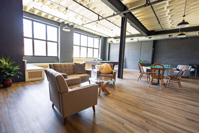 A view into the community room with seating areas, a pool table and a poker table at the Waterfront Warehouse in Pittston, PA.