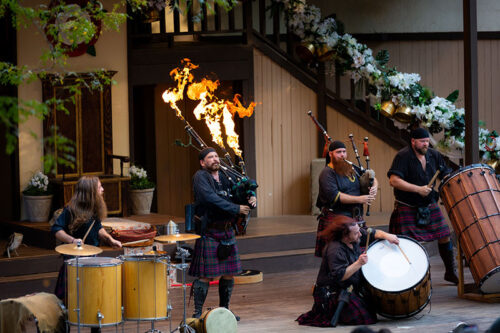 Flames coming out of a bag pipe instrument as a band plays on stage at the PA Renaissance Faire in Mount Hope, PA.