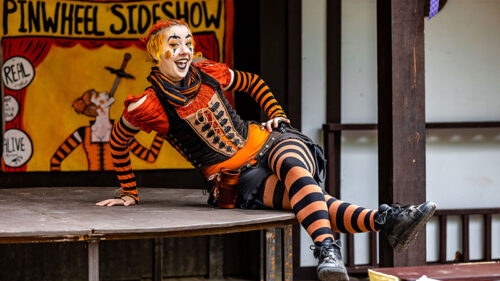 A woman in a orange and black costume on stage at the PA Renaissance Faire in Mount Hope, PA.