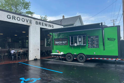 A green food truck parked outside Groove Brewing in Scranton, PA.
