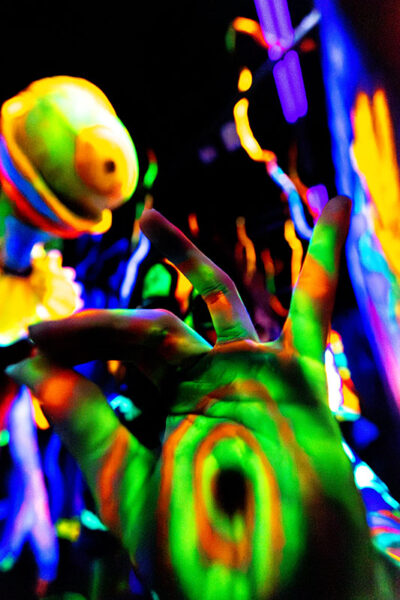 An actor dressed in neon colors under a blacklight puts his hand in front of the camera at Reaper's Revenge in Scott Twp., PA near Scranton.