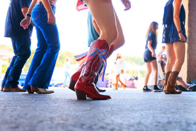 A close up photo of red cowgirl boots with a red white and blue ribbon attached at the Boots & Brews Music Festival at Clubhouse 315 in Wilkes-Barre, PA.