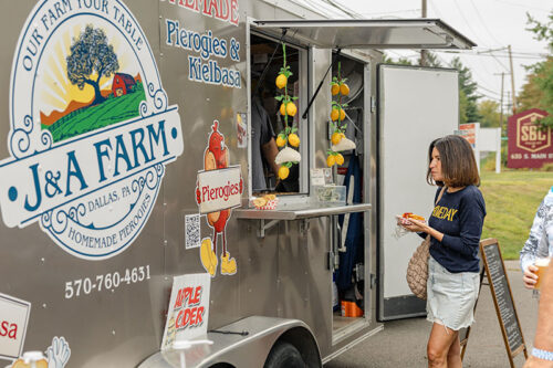 A customer eating her food at J & A Farm's food truck at Susquehanna Brewing Company's Oktoberfest