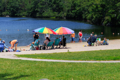 Beach-goers sit under umbrellas at Tobyhanna State Park in Tobyhanna, PA.