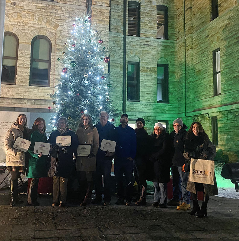 A group of small business owners pose for a photo after being awarded for their winning contributions to Holiday Window Showcase in Downtown Scranton.