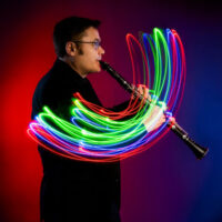 Promotional image for Dreams & Klezmer at the WVIA Sordoni Theater in Pittston, featuring a clarinetist surrounded by colorful light trails against a dark background.