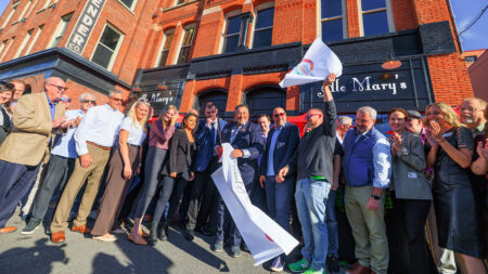 A group of people celebrate the ribbon cutting outside of Ale Mary's in Scranton, PA.