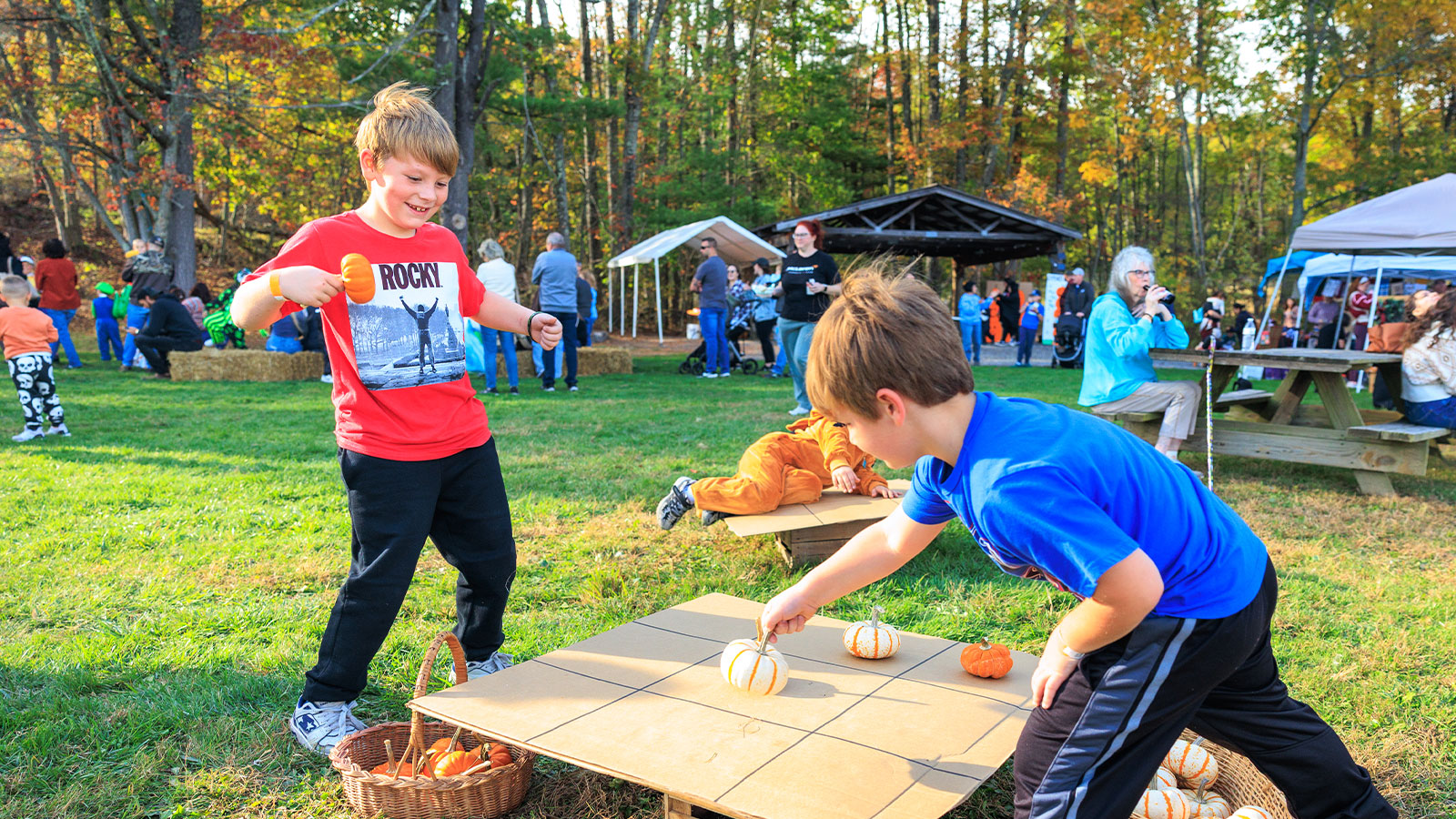 Two boys play tic tac toe with orange and white mini pumpkins at Dymond's Farm and Farm Market in Dallas, PA.