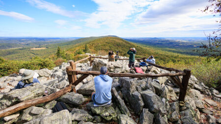 A group of birdwatchers sit on top of the north lookout observing migrating birds at Hawk Mountain Sanctuary in Kempton, PA.
