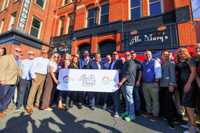 A group of representatives and local dignitaries gather outside Ale Mary's at the Bittenbinder in Scranton for the ribbon cutting ceremony for Madame Jenny's.