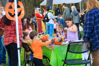 A group of children decorate pumpkins around a table at Dymond's Farm and Farm Market in Dallas, PA.