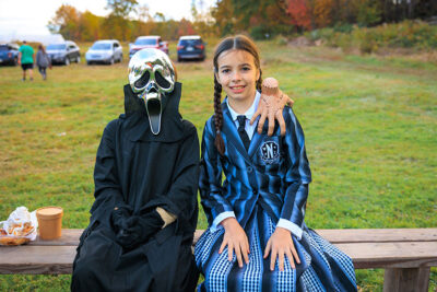 A young boy and girl dressed as Ghostface and Wednesday Adams smile for the camera at Dymond's Farm and Farm Market in Dallas, PA.