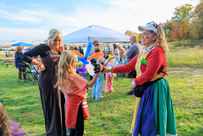 A girl smiles as she receives her balloon from an artist at Dymond's Farm and Farm Market in Dallas, PA.