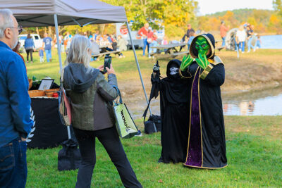 Two children dressed as an alien and skeleton pose as their mom snaps their photo on her phone at Dymond's Farm and Farm Market in Dallas, PA.