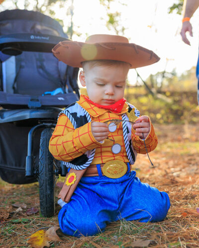 A young boy dressed as Woody from Toy Story inspects a leaf at Dymond's Farm and Farm Market in Dallas, PA.