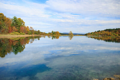 A view across a reflective pond on an autumn day at Dymond's Farm and Farm Market in Dallas, PA.
