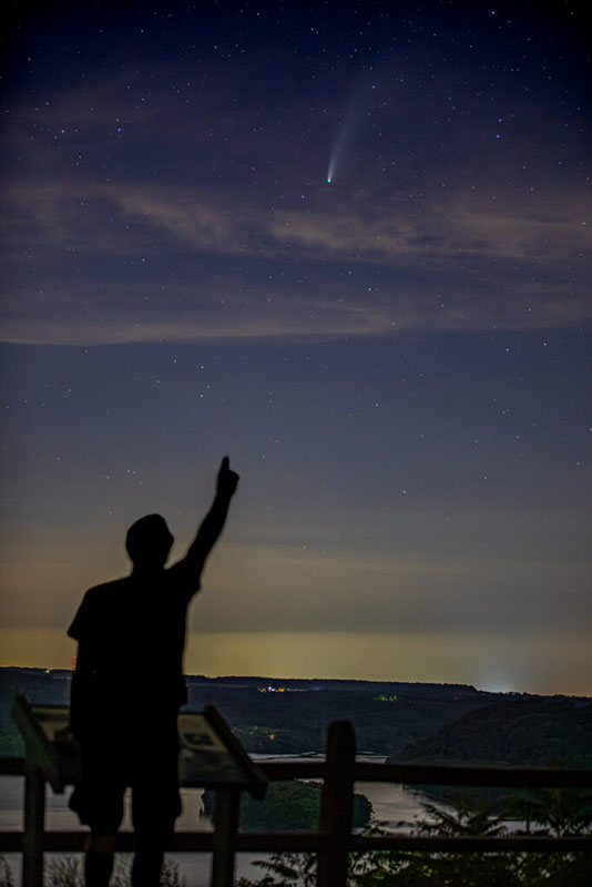 A man pointing into the night sky at a meteor during a meteor shower near the Susquehanna River in Holtwood, PA.