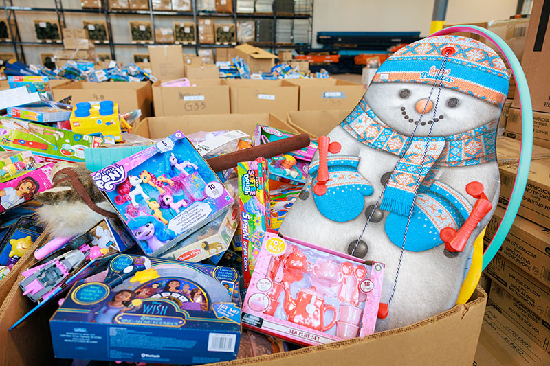 A large collection of toys, including a snowman sled and boxed games, is sorted for Toys for Tots, Wyoming, PA.