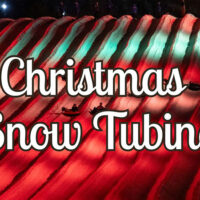 Promotional image for Christmas Snow Tubing showing a brightly lit red-and-green tubing hill with riders sliding down under festive lighting at Blue Mountain Resort.