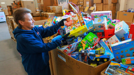A volunteer sorts through a large donation bin filled with toys at Toys for Tots, Wyoming, PA.