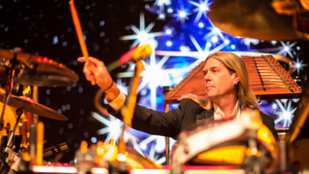 A dummer with Mannheim Steamroller performs on stage.