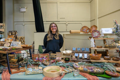 A smiling vendor at the 2025 Artisans' Marketplace at the Waverly Community House