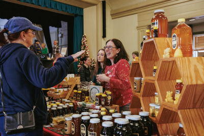 A vendor interacts with a customer at the 2025 Artisans' Marketplace at the Waverly Community House