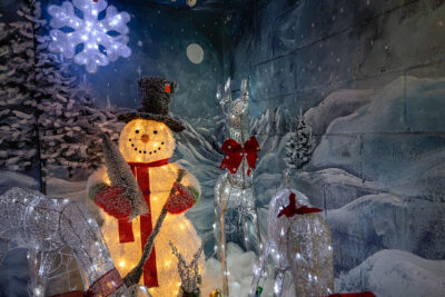 A snowman in front of a wall painting at Main Hardware Christmasland