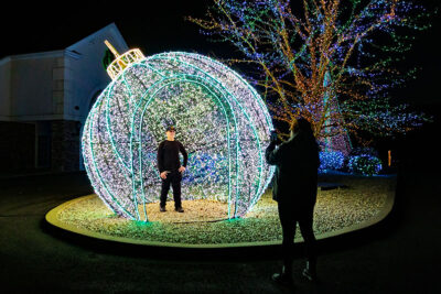 A boy gets his photo taken inside a glowing Christmas ornament at Stone Hedge Golf Course during the Festival of Lights in Tunkhannock PA.