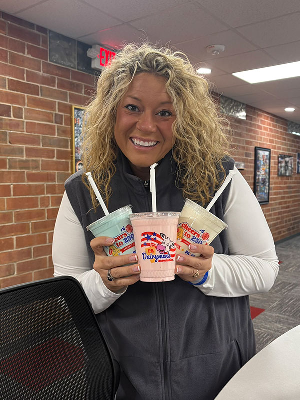 A woman poses with three milkshakes at the PA Farm Show in Harrisburg, PA.