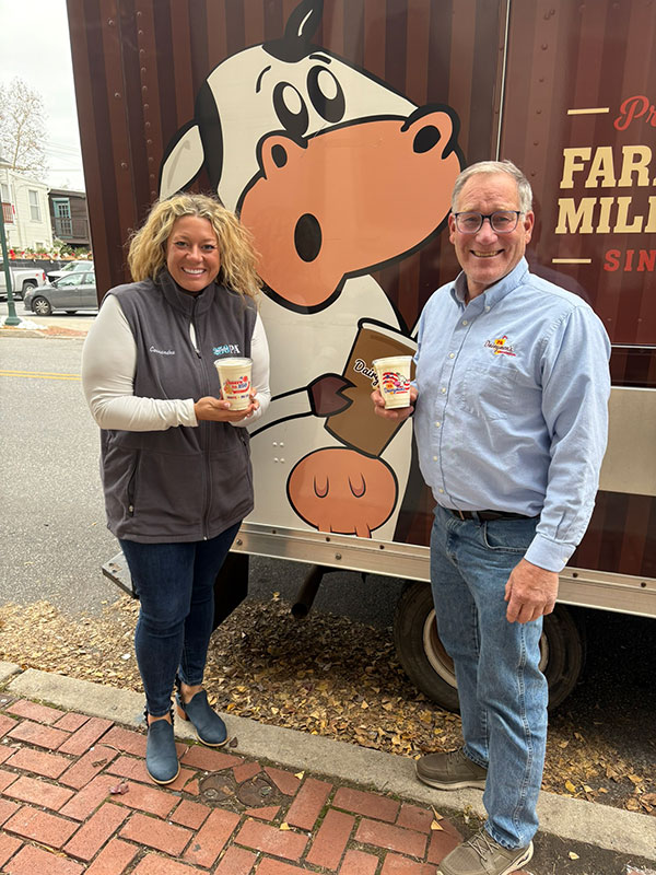 A man and a woman pose for a photo while holding milkshakes at the PA Farm Show in Harrisburg, PA.