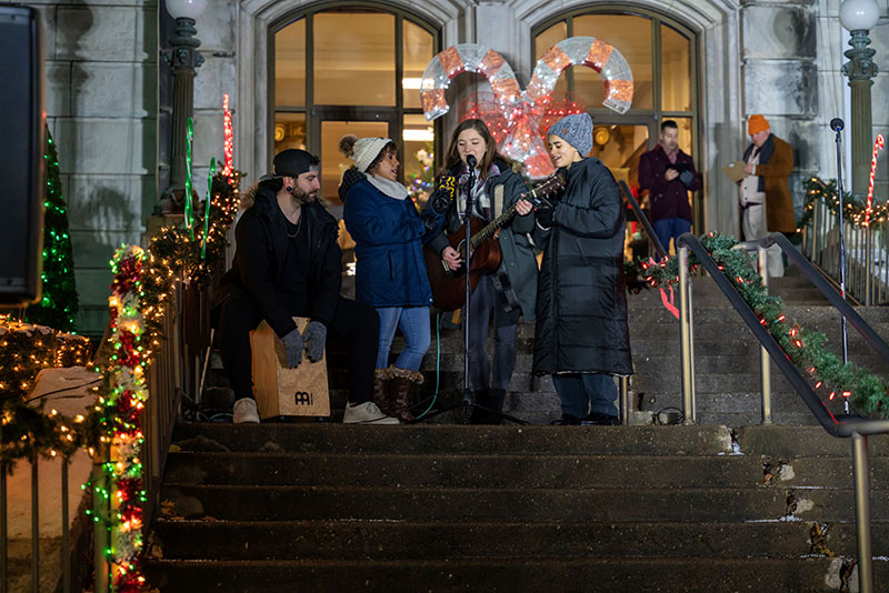 Local musicians perform on the decorated front steps of a downtown building during CAN DO Community Christmas in Hazleton, PA.