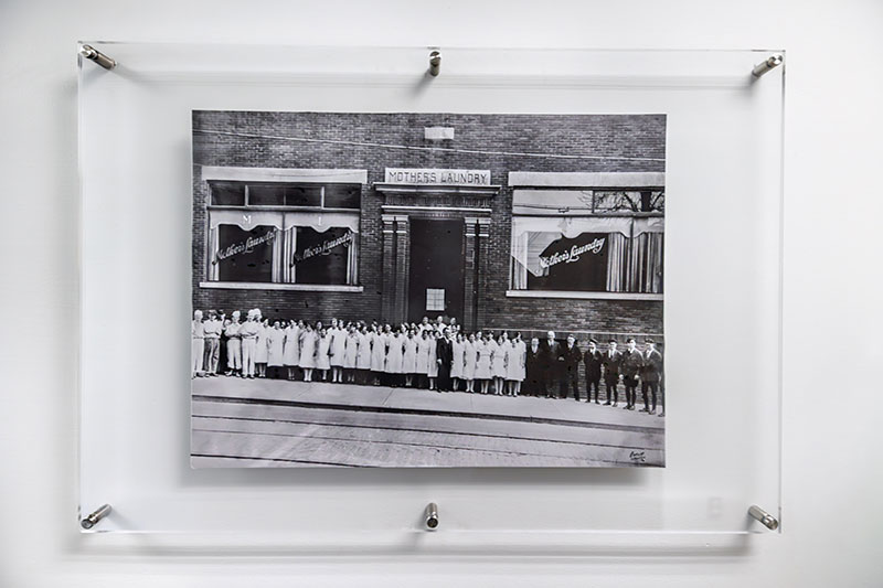 A framed historic photo of Mother’s Laundry in Dunmore, Pennsylvania, displayed at Dempsey Uniform & Linen Supply in Jessup, PA.