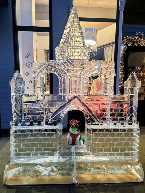 A dog poses for a photo at an ice sculpture selfie station a Downtown on Ice in Scranton, PA.