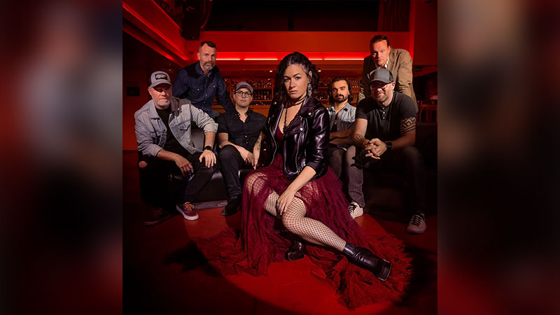 Promotional photo for Bywater Call at Mauch Chunk Opera House in Jim Thorpe, showing the band posed together in a warmly lit indoor setting.