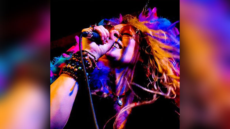 Promotional image for Experience Janis – The Tribute to Janis Joplin at Mauch Chunk Opera House in Jim Thorpe, showing a singer holding a microphone with colorful lighting and expressive movement.