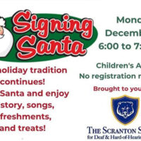 A flyer for Signing Santa in Scranton, PA with an illustration of Santa signing “I love you,” showing text that reads: “Our holiday tradition continues! Meet Santa and enjoy a story, songs, refreshments, and treats! Monday December 8, 6:00 to 7:00 PM, Children’s Area, No registration required, Brought to you by The Scranton School for Deaf & Hard-of-Hearing Children.