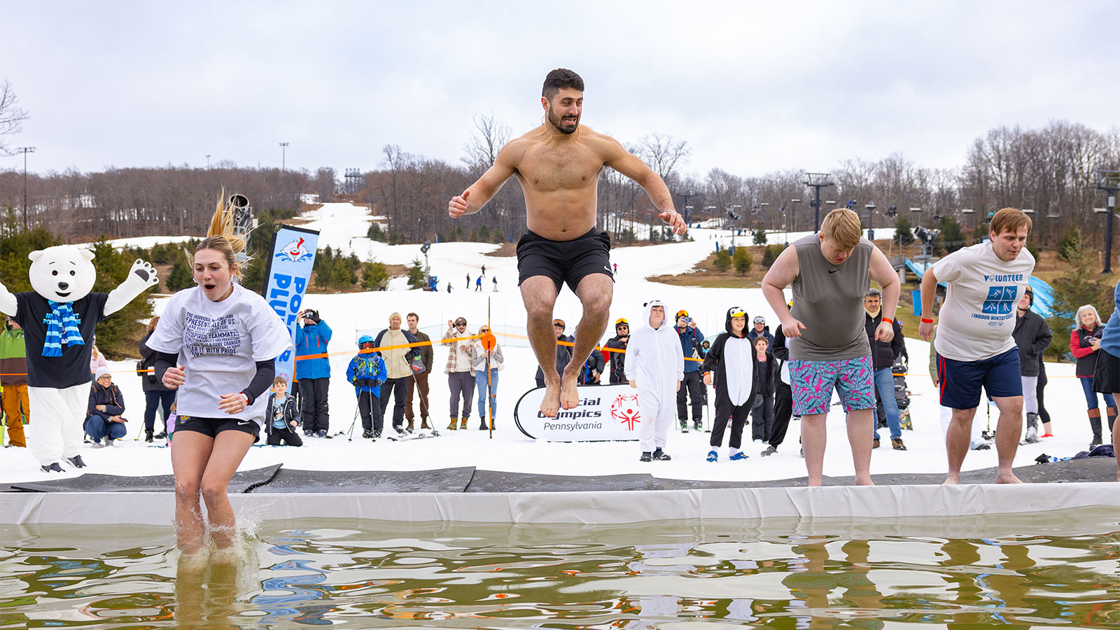 A row of participants jumping into the cold plunge at the Northeast Polar Plunge at Montage Mountain in Scranton, PA.
