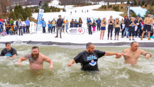 A row of participants wading in the cold plunge at the Northeast Polar Plunge at Montage Mountain in Scranton, PA.