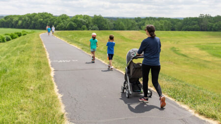 A woman pushing a stroller behind two children as they walk along the Luzerne County Levee Trail in Northeastern PA.