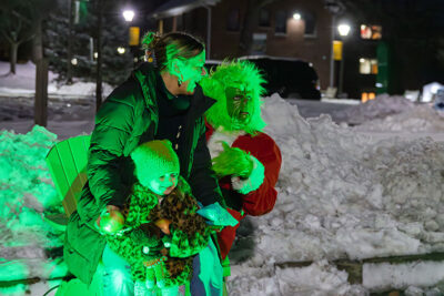 A mom and daughter laugh as they sit on the Grinches lap for a photo during the Merry and Bright event at Marywood University in Scranton, PA.