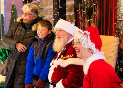 A boy and his grandmother laugh with Santa and Mrs. Claus as they get their photo taken during the Merry and Bright event at Marywood University in Scranton, PA.