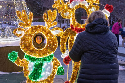 A little boy with his head in a glowing reindeer cutout poses for a picture during the Merry and Bright event at Marywood University in Scranton, PA.