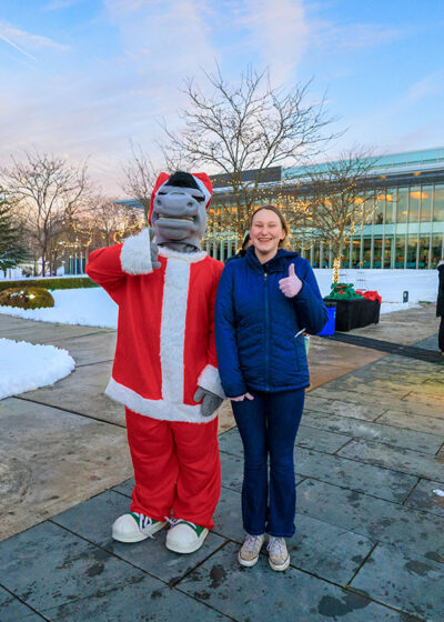 A girl poses with a person dressed up as Dominick the Donkey during the Merry and Bright event at Marywood University in Scranton, PA.